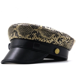 Detail of snake skin pattern flat top hat with black faux leather brim and gold side button