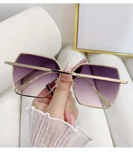 Detail view of oversized rimless geometric sunglasses with purple gradient lenses and gold frame