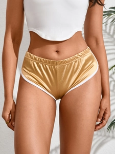 Dettaglio degli shorts da yoga oro metallizzato con bordo bianco ed elastico in vita