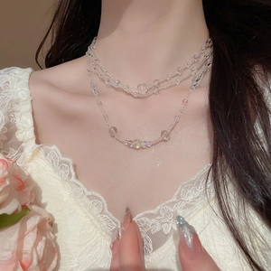 Three-layer beaded star and heart necklace displayed on a model's collarbone