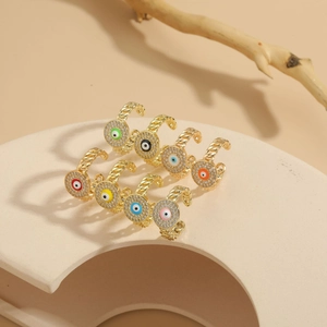 Macro detail of gold-plated evil eye rings with multi-colored zircons and braided bands