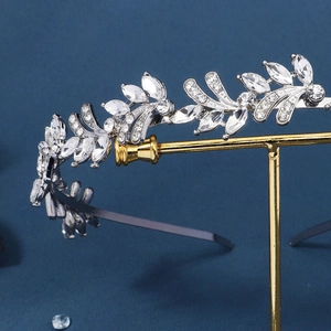 Macro view of silver leaf pattern hairband with sparkling rhinestones on blue background