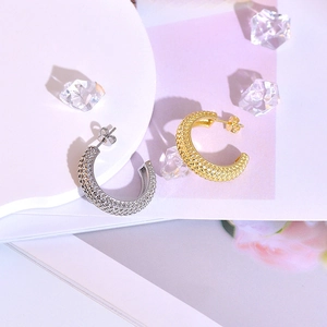 Modern C-shaped mesh earrings in gold and silver finish with woven metal texture