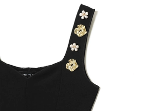 Detail of black top with pearl flowers and gold metal floral straps in size M