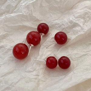 Macro detail of red agate ball earrings in various sizes with 925 sterling silver pins