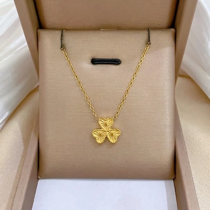 Titanium steel gold clover heart necklace with laser texture in a jewelry box