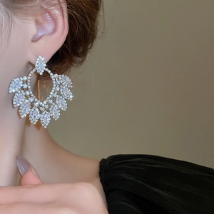 Detail of luxury teardrop zircon earrings shown on a model for an elegant gala look