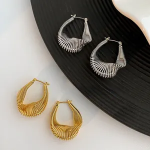 Detailed macro of gold and silver twisted wire texture on geometric hoop earrings