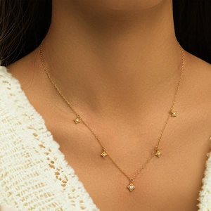 Detailed view of a gold S925 silver necklace with five sparkling diamond star pendants