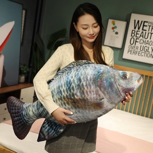 Realistic large plush fish pillow with digital scale print shown in a bedroom setting