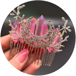 Boho silver branch and moon hair comb with pink raw crystals held in hand against black backdrop