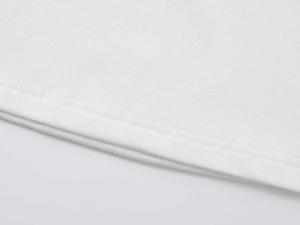 Détail de l'ourlet à double couture et de la texture en maille blanche du t-shirt femme