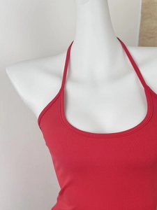 Detail of red halter neck slim fit top showcasing stretchy fabric on a white mannequin