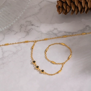 Minimalist 18K gold plated chain bracelet featuring three black zircons on marble