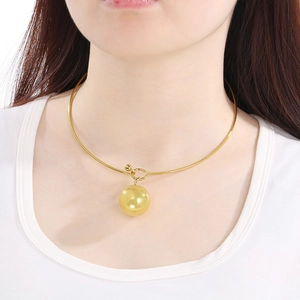 Vue détaillée d'un collier ras du cou doré en acier inoxydable avec pendentif sphérique