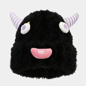 Close-up of black plush monster beanie with purple horns and creative cartoon face details