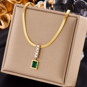 Detail of gold snake chain necklace featuring green and clear square gemstones