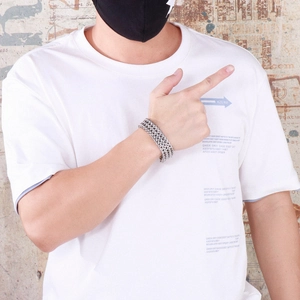 Detail shot of men's multi-layered silver steel chain bracelet on model's wrist
