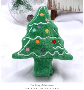 Detail of green plush Christmas tree toy with colorful embroidery on white rug