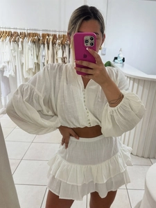 White cotton two-piece set featuring puff sleeve crop top and tiered mini skirt outfit