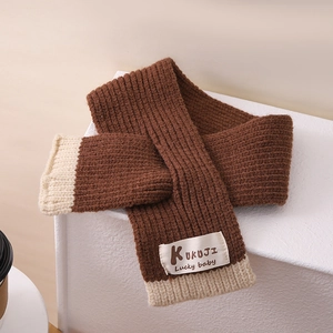 Detail eines dicken Strickschals in Karamel-Kaffee und Beige mit weicher Strickstruktur