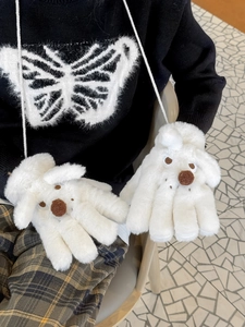 Detail of white plush puppy gloves showing soft faux fur texture and hanging neck cord