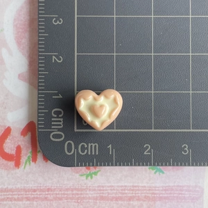 Detailed view of 1cm peach resin heart charm on measurement scale for crafts and nails
