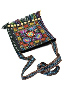 Detail of bohemian embroidery and long fringe on a black ethnic crossbody bag