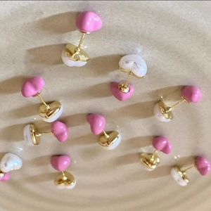 Sweet pink and white heart pearl studs on a textured ceramic tray minimalist design