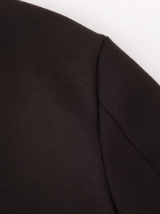 Close-up of thick dark brown wool fabric texture and shoulder seam on a long coat