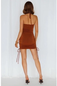 Detail of caramel halter mini dress featuring adjustable side drawstrings and backless design