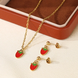 Detailed view of red strawberry enamel pendant on a golden titanium steel necklace chain