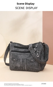 Detail view of a charcoal grey canvas crossbody bag with multiple zip pockets and rivets