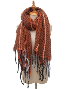 Detail shot of orange-brown herringbone scarf with soft decorative fringe on mannequin