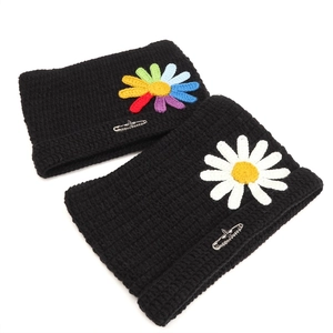 Black knit cat ear beanie with crochet daisy and decorative metal safety pin accessory