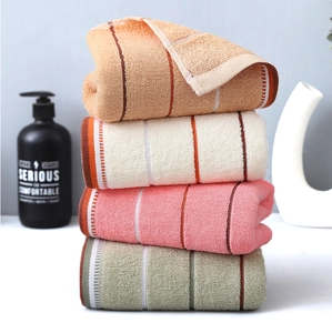 Close-up of stacked colorful striped cotton towels showing soft terry texture and neat edges