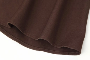 Macro detail of dark brown twill fabric showing the smooth hemline and high-quality stitching