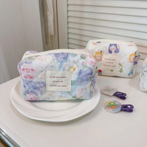 Detail of quilted cotton makeup bag with floral prints and chic French text embroidery