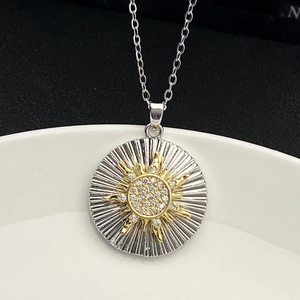 Macro view of sunburst pendant with sparkling crystals on gold and silver two-tone metal