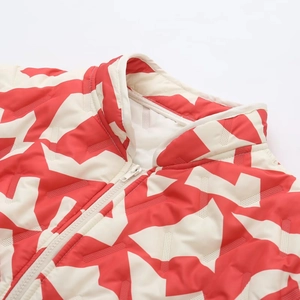 Détail du col montant et du zip sur veste à motif géométrique rouge et blanc