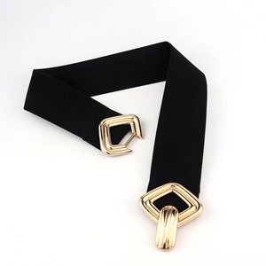 Gros plan d'une ceinture élastique noire avec boucle métallique dorée géométrique