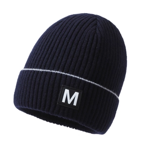 Navy blue ribbed knit beanie with white stripes and a square M-letter patch