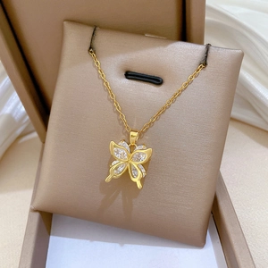 Close-up of a gold butterfly pendant necklace with clear zircons in a jewelry box