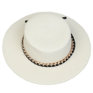 Detail view of woven texture on wide brim straw hat with decorative gold chain strap
