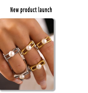 Detail of square gold and silver rings with inlaid pearls on a model's hand
