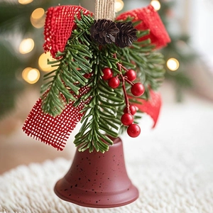 Close-up of Christmas bell with red burlap bow, pine needles and natural pine cone