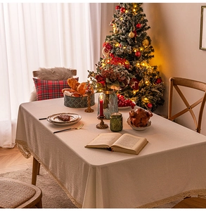 Close-up of cream lace tablecloth edge with festive Christmas dining table decor