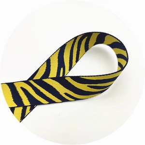 Detail of adjustable zebra print bag strap in yellow and black woven fabric material