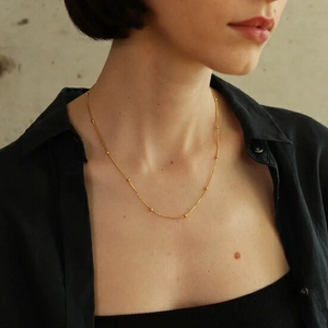 Minimalist 18k gold plated titanium snake chain necklace with small beads on a model