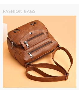 Détail d'un sac bandoulière marron en similicuir avec poches zippées et fermoir cœur